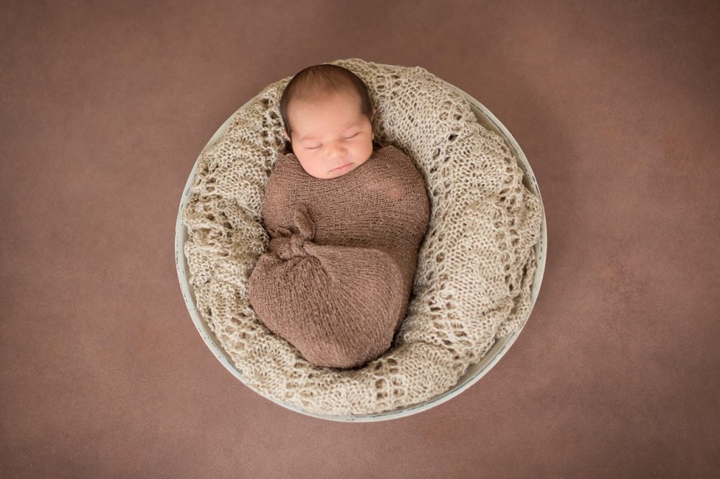 baby liegt in einer Schale und schläft. neugeborenenfotos von Ella Photography bei duesseldorf