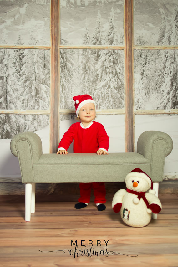kleiner junge steht hinter einer bank und trägt ein weihnachtsmannkostüm, weihnachtsshooting düsseldorf von ella photo