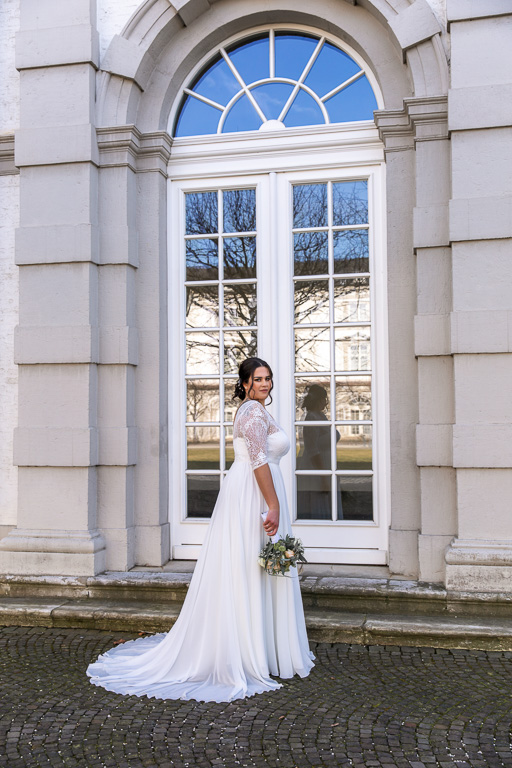 Braut steht vor Fenster und spiegelt sich darin am Schloss Bensberg in Bergisch Gladbach, Ella Photography, Fotografie, Hochzeit, Erkrath, Düsseldorf, Hilden, Mettmann